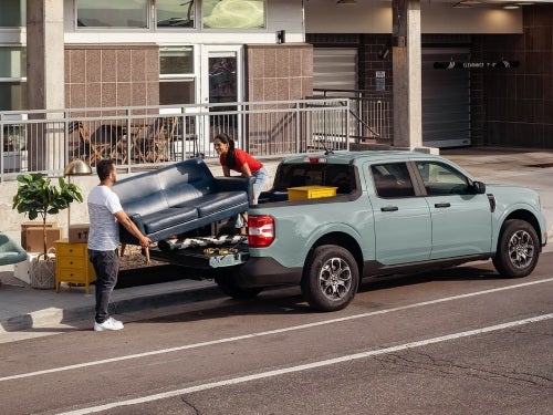 2024 Ford Maverick parked on street and a couple loading the bed of the truck