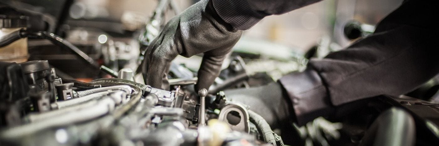Close up view of a service tech working on an a/c compressor