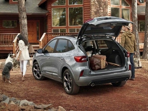 2024 Ford Escape Plug-in Hybrid parked outside a cabin with back door open and cargo area full of bags